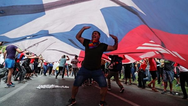 demonstrators_carry_a_giant_chilean_national_flag_during_a_protest_against_neoliberal_economic_model_in_santiagox_chile_oct__25x_2019_.jpg_1718483346