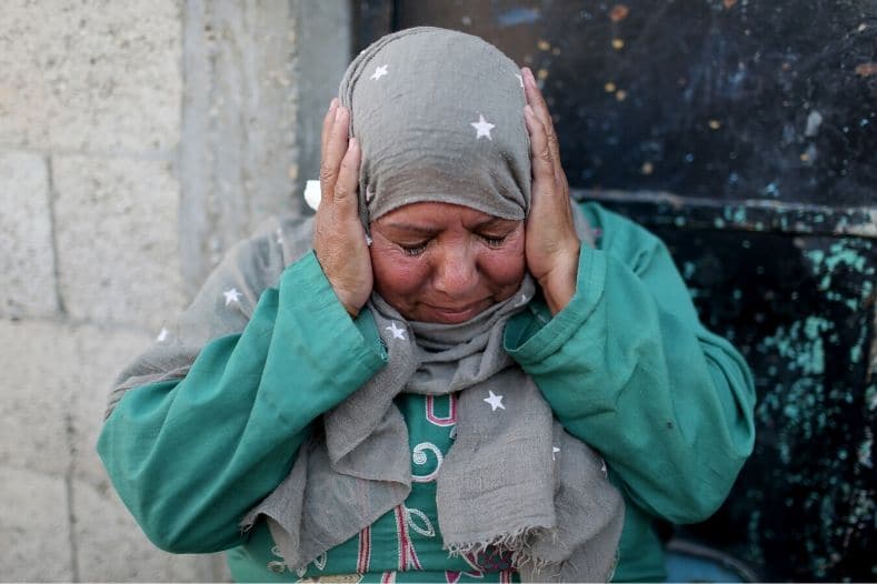 a_palestinian_woman_reacts_as_she_sits_outside_her_home_in_the_southern_gaza_strip_november_12x_2019_