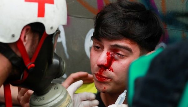 an_injured_student_is_helped_by_medical_staff_during_a_protest_against_president_sebastian_pixera_in_santiagox_chile_nov__8x_2019_.jpg_1718483346