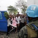 Haitians-protesting-UN-blue-helmets-in-foreground.jpg