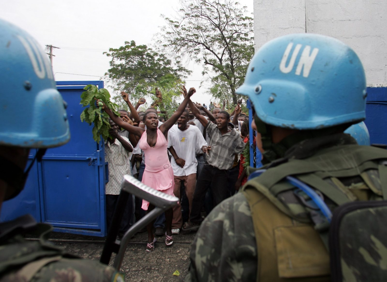 Haitians-protesting-UN-blue-helmets-in-foreground.jpg