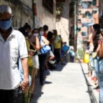 People make a line to receive food from a charity, in the slum of Carapita, during the nationwide quarantine due to the coronavirus disease (COVID-19) outbreak, in Caracas
