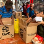 Inhabitants of Barrio Unión in Petare, Caracas, open CLAP food boxes delivered by the productive organization Colectivo Resistencia y Rebelión de Caracas, April 4, 2019. Photo: Eva Marie Uzcátegui/Getty Images.