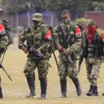 Members of the Colombian guerrilla ELN walk to a military base to hand over their weapons.