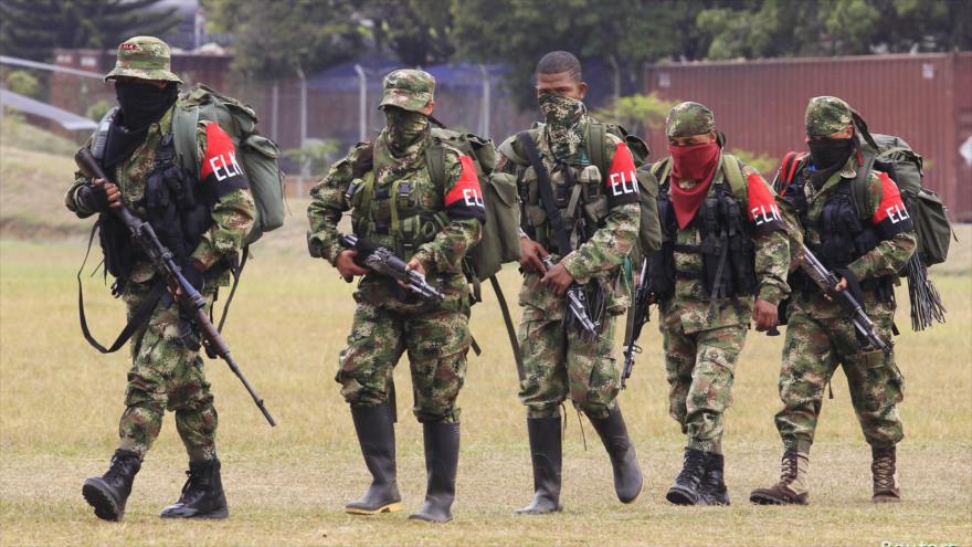 Members of the Colombian guerrilla ELN walk to a military base to hand over their weapons.