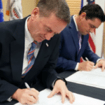 Featured image: U.S. Agency for International Development Administrator Mark Green with Carlos Vecchio, Venezuelan fake ambassador to the United States at the signing of their "deal". Photo by: Mark Green via Twitter.