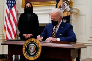 Featured image: President Biden signing executive orders last February at the White House, with Vice President Kamala Harris. Photo: Evan Vucci/Associated Press 