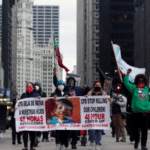 Protesters holding signs navigate along Chicago's South Michigan Avenue during a peaceful protest, on April 14, 2021, ahead of the video release of the fatal police shooting of 13-year-old Adam Toledo.Shafkat Anowar / AP