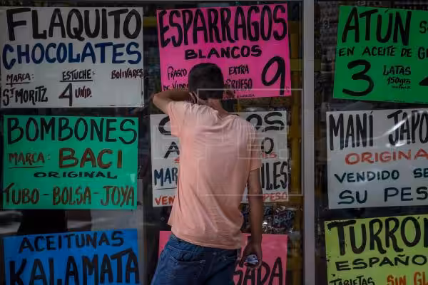 Featured image: A man observes inside a display case from which posters with food prices are strained in Caracas (Venezuela). EFE / Miguel Gutiérrez / Archive.