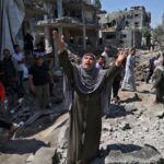 Featured image: Palestinian woman phrasing Allah in the middle of the destruction of Israeli bombings. File photo.
