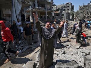 Featured image: Palestinian woman phrasing Allah in the middle of the destruction of Israeli bombings. File photo.