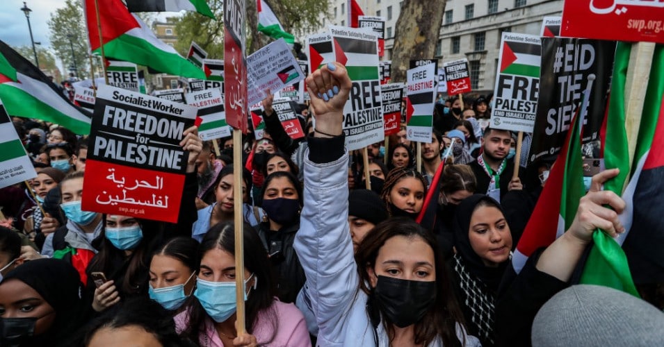 Demonstrators hold banners and placards outside Downing Street during a "Save Sheikh Jarrah" demonstration in London on Tuesday, May 11, 2021. At least 24 Palestinians were killed Monday, May 10 in Israeli air raids on Gaza Strip. (Photo: Vudi Xhymshiti/Anadolu Agency via Getty Images)