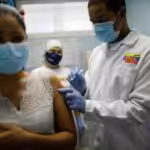 Featured image: Venezuelan woman being vaccinated against COVID-19. File photo.