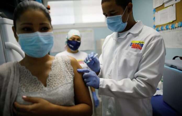 Featured image: Venezuelan woman being vaccinated against COVID-19. File photo.