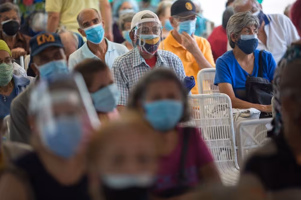 Featured image: Venezuelan senior citizens waiting to be vaccinated in the umprecedented vaccination campaign launched by President Maduro despite US and European blockade. Photographer: Manaure Quintero/Bloomberg.