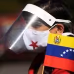 Young Venezuelan wearing a mask and a face screen protector with a Venezuelan flag. File photo.