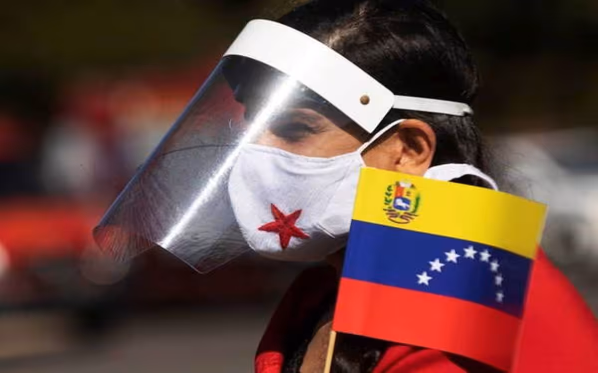 Young Venezuelan wearing a mask and a face screen protector with a Venezuelan flag. File photo.