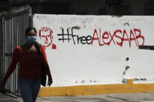 A pedestrian passes in front of “Free Alex Saab” graffiti “ in Caracas, on Feb. 4. Photographer: Carlos Becerra/Bloomberg.