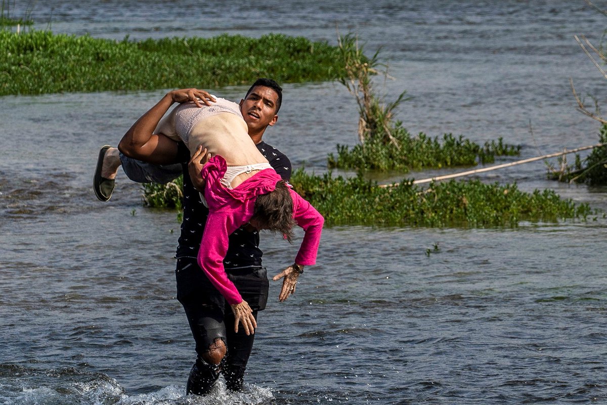 Young Venezuelan (Cesar Padron) helping and older woman to cross the Rio Grande, a photo used to magnify Venezuela's migration issue. File photo.