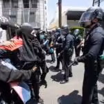 Police in full gear in front of a small peaceful protest defending transgender people rights in LA, California. Photo courtesy of the New York Post.