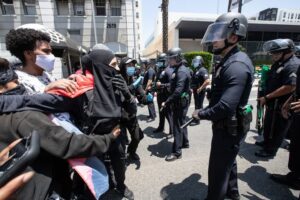 Police in full gear in front of a small peaceful protest defending transgender people rights in LA, California. Photo courtesy of the New York Post.