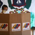 A man stands at a voting booth at a polling station during parliamentary election in Caracas, Venezuela, December 6, 2020 [Manaure Quintero/Reuters]