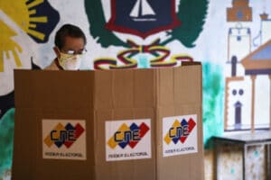 A man stands at a voting booth at a polling station during parliamentary election in Caracas, Venezuela, December 6, 2020 [Manaure Quintero/Reuters]