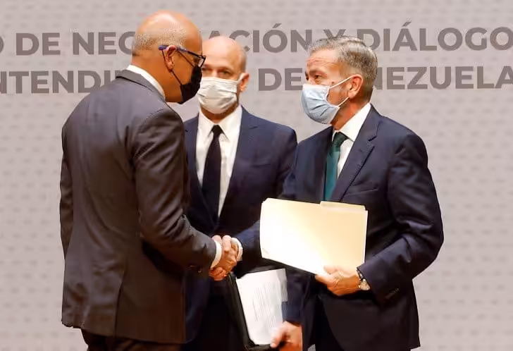 Jorge Rodriguez, head of the Venezuelan government delegation shaking hands with Gerardo Blyde, head of the extreme right opposition delegation while being watch by the head of the Norwegian mediation delegation Dag Nylander. Photo courtesy of Twitter / @AissateleSUR .