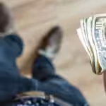 Person carrying US dollars. File photo courtesy of RedRadioVE.