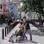 A Venezuelan family walking in downtown Caracas, all wearing their face masks. File photo.