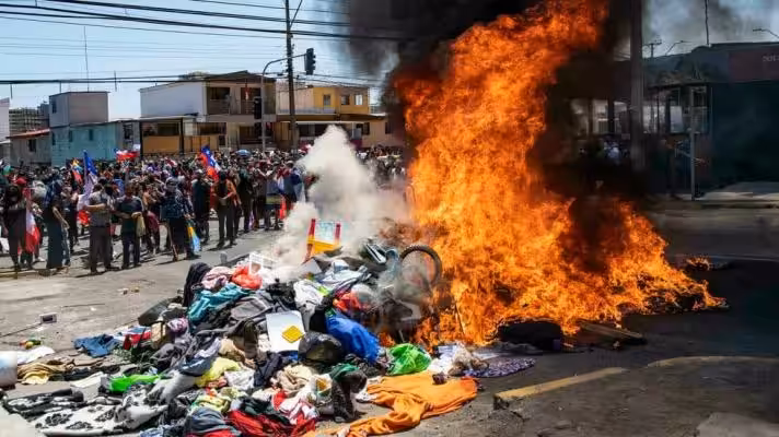 People burn tents, clothes and other belongings of Venezuelan migrants during an anti-immigration march, in Iquique, Chile, on September 25, 2021 (Photo: EFE).