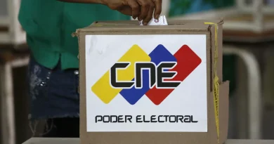 Person dropping a voting receipt in CNE's security boxes. Photo courtesy of REUTERS / Carlos Garcia Rawlins.