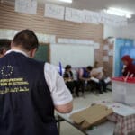 Observers from the European Union monitor the election process inside a polling station outside Tunis during the first round of the presidential election on September 15, 2019. (Mosa’ab Elshamy/AP).
