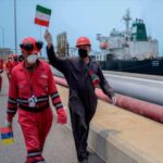 Workers with Iranian and Venezuelan flags celebrate the arrival of the Iranian oil tanker "Fortune" at a Venezuelan refinery. Photo: AFP.