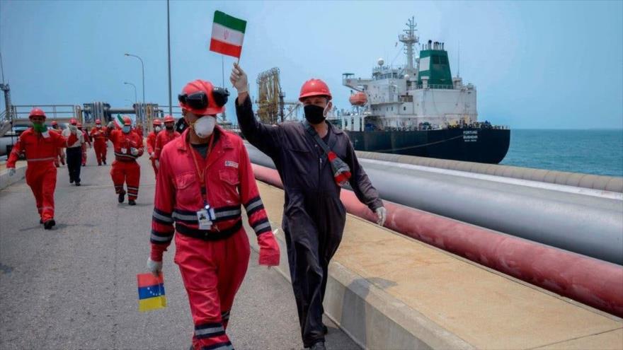 Workers with Iranian and Venezuelan flags celebrate the arrival of the Iranian oil tanker "Fortune" at a Venezuelan refinery. Photo: AFP.