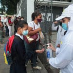 Venezuelan kid entering school in Caracas and behind dispensed with hand sanitizer. Photo courtesy of Jacobo Méndez / Últimas Noticias.