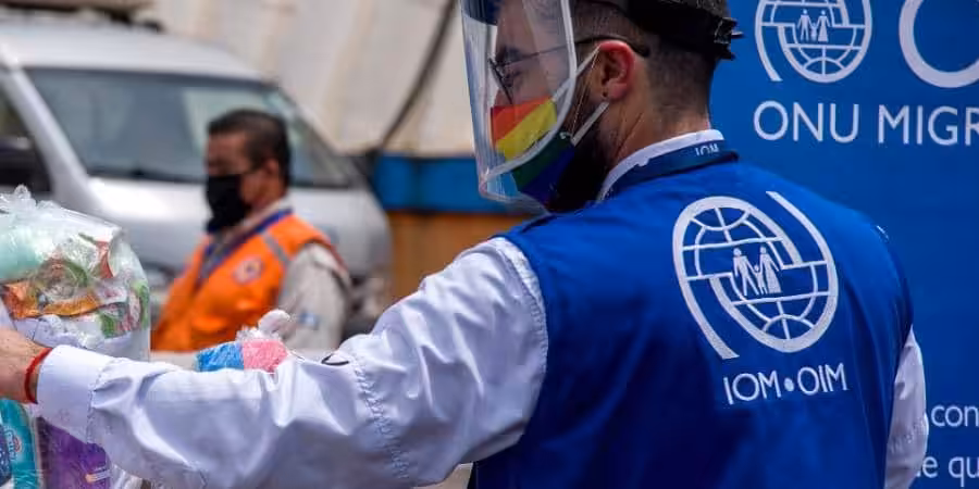 IOM officer in a street wearing a vest and with COVID-19 protective gear. Referential photo.