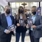 Alex Saab's wife Camila Fabri holding the book "Letters from Alex Saab since his Kidnapping" (center), Minister for Culture Ernesto Villegas (right) and Venezuela's National Book Center president, Raúl Cazal (left). Photo courtesy of Twitter /@PedroKonductaz.