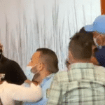 Featured image: Moment captured by Telesur when opposition candidate for Bolivar state Raul Yusef slapped opposition candidate Americo de Grazia in the face. Screenshot from Telesur footage.