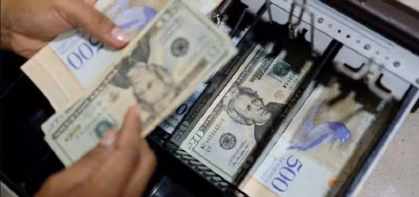 Cash register in Venezuela containing US dollars and Venezuelan bolivars. File photo courtesy of Banca y Negocios.