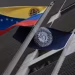A Venezuelan and a Central Bank of Venezuela (BCV) flag in front ot the BCV headquarters in Caracas, Venezuela. File photo.