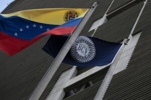 A Venezuelan and a Central Bank of Venezuela (BCV) flag in front ot the BCV headquarters in Caracas, Venezuela. File photo.