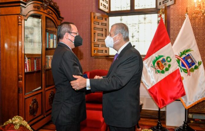Venezuelan ambassador to Peru, Alexander Yánez, being greeted by Peruvian chancellor Oscar Maurtúa de Romaña. Photo by Twitter / @CancilleriaPeru.