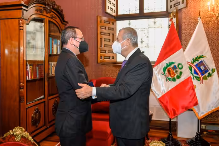 Venezuelan ambassador to Peru, Alexander Yánez, being greeted by Peruvian chancellor Oscar Maurtúa de Romaña. Photo by Twitter / @CancilleriaPeru.