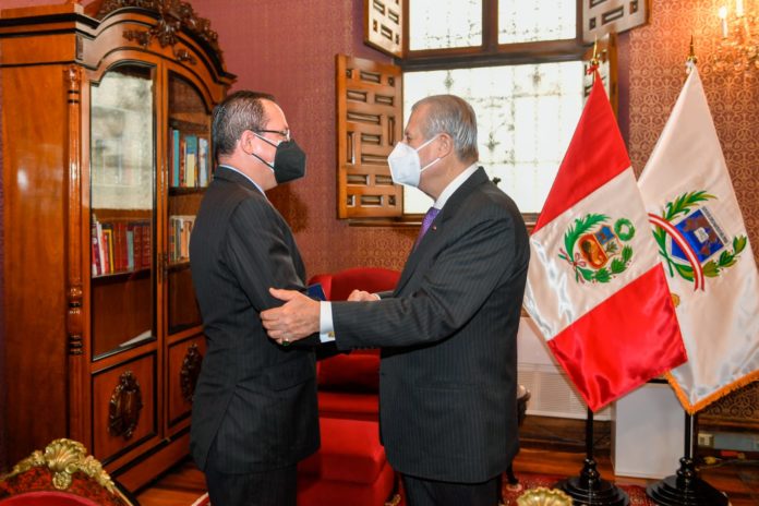 Venezuelan ambassador to Peru, Alexander Yánez, being greeted by Peruvian chancellor Oscar Maurtúa de Romaña. Photo by Twitter / @CancilleriaPeru.
