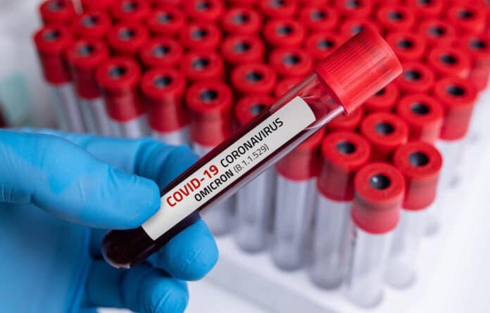 Person holding a blood sample of COVID-19 Omicron B.1.1.529 Variant and general data of COVID-19 Coronavirus Mutations. Photo by Getty Images.