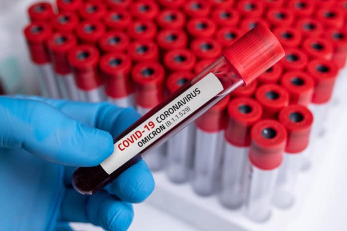 Person holding a blood sample of COVID-19 Omicron B.1.1.529 Variant and general data of COVID-19 Coronavirus Mutations. Photo by Getty Images.