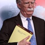 John Bolton holding a notepad with a handwriting mentioning the need to move 5000 troops to Colombia. One of Bolton's "biggest achievements" as Trump's national security advisor. Photo by Win McNamee, Getty Images.