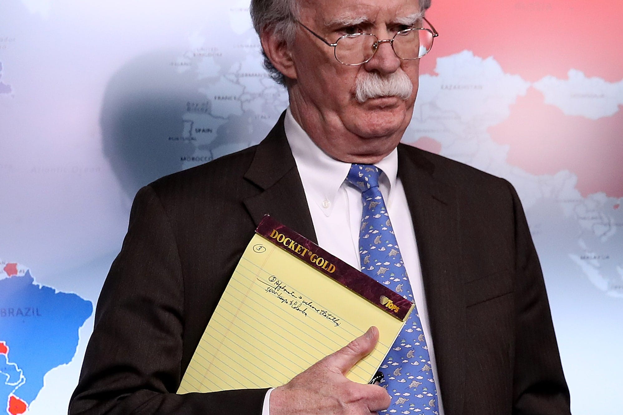 John Bolton holding a notepad with a handwriting mentioning the need to move 5000 troops to Colombia. One of Bolton's "biggest achievements" as Trump's national security advisor. Photo by Win McNamee, Getty Images.