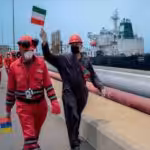 Workers carrying Iranian and Venezuelan flags celebrate the arrival of Iranian tanker Fortune at a Venezuelan refinery.